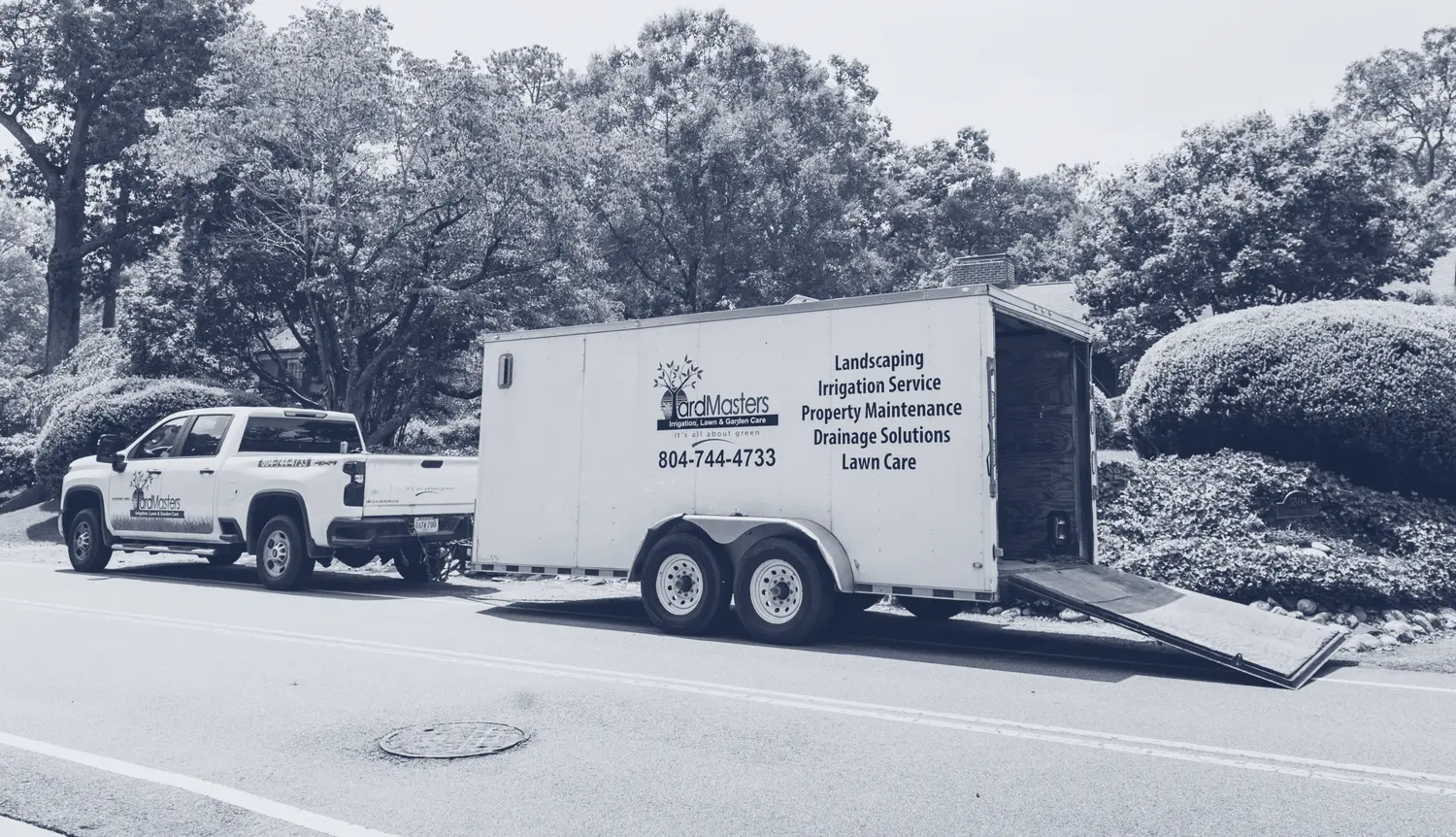 The YardMasters truck and trailer parked at a client's curb, in one ink.